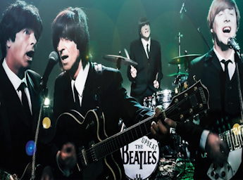 A picture of the Upbeat Beatles band dressed as the Beatles and performing on stage.